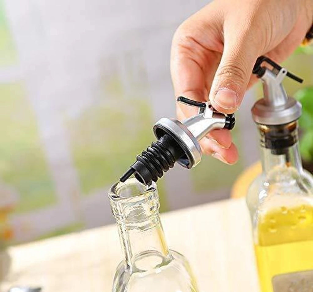 Person using a bottle stopper on a glass bottle with a blurred outdoor background
