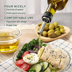 Olive oil bottle with a pouring spout being used to drizzle olive oil over a salad.
