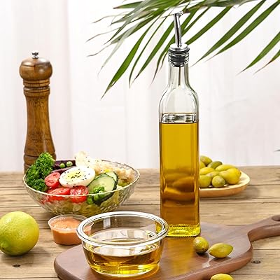 Bottle of olive oil on a table with a salad and vegetables