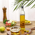 Bottle of olive oil on a table with a salad and vegetables