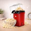 Red popcorn maker with popped popcorn on a wooden surface