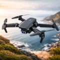 Black drone flying over a scenic landscape with water and mountains.