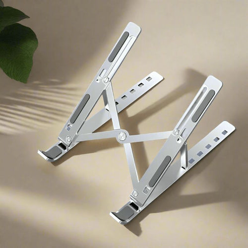 Metallic folding stand on a beige surface with a plant leaf in the corner