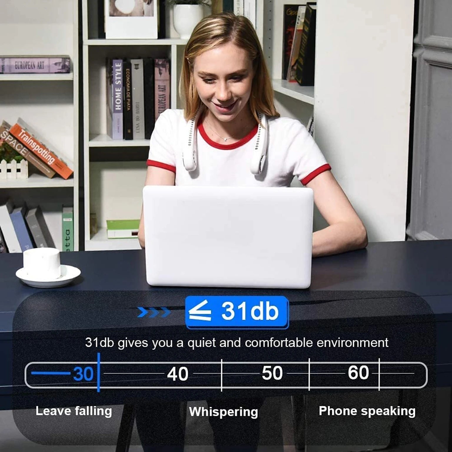 Woman sitting at a desk with a laptop, surrounded by books and a cup.