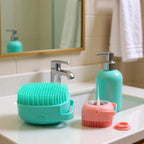 Bathroom counter with teal cleaning brush, pink scrubber, and soap dispenser.